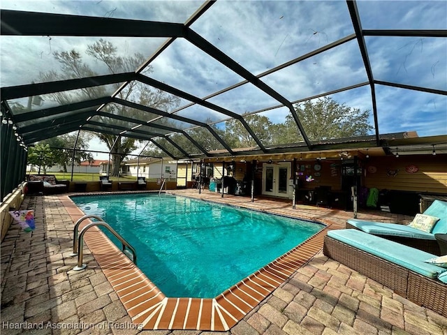 view of pool featuring french doors, a patio, and glass enclosure