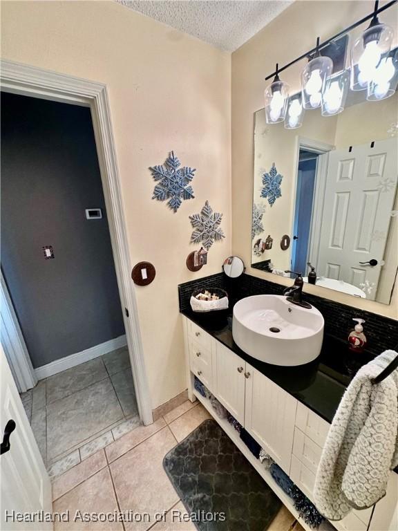 bathroom featuring vanity, tile patterned flooring, and a textured ceiling