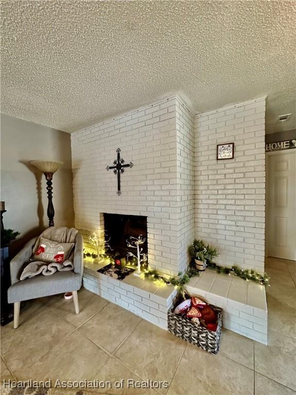 unfurnished living room featuring brick wall, tile patterned flooring, a brick fireplace, and a textured ceiling