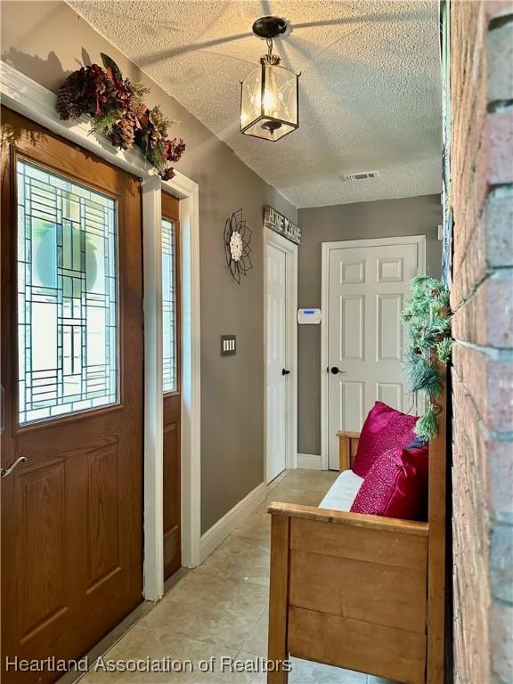 tiled foyer entrance featuring a textured ceiling