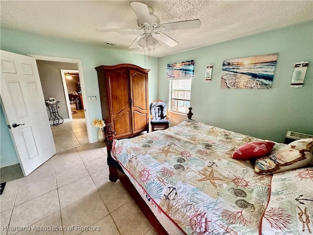 bedroom with ceiling fan, a textured ceiling, and light tile patterned floors