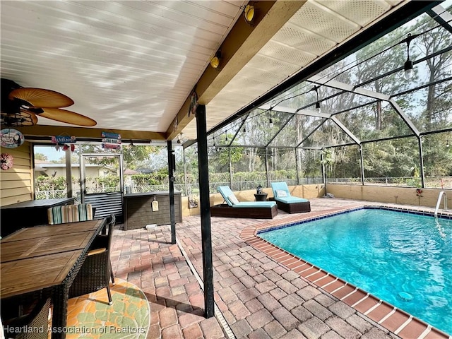 view of swimming pool with a patio, an outdoor bar, ceiling fan, and glass enclosure