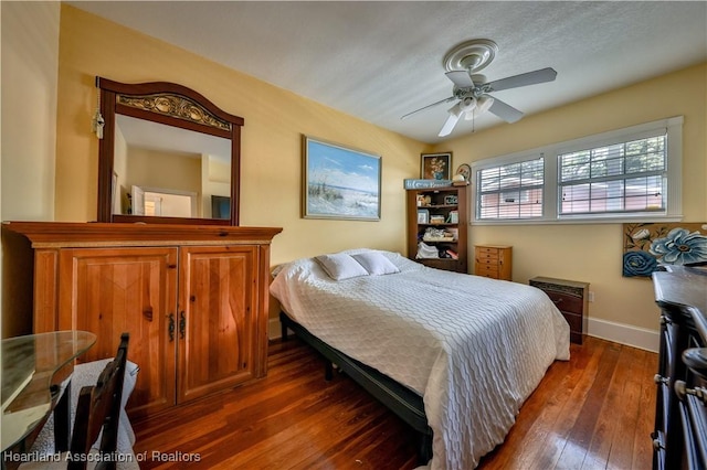 bedroom with ceiling fan and dark hardwood / wood-style floors