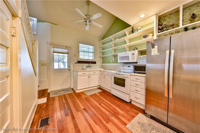 kitchen with ceiling fan, lofted ceiling, white appliances, white cabinets, and light wood-type flooring