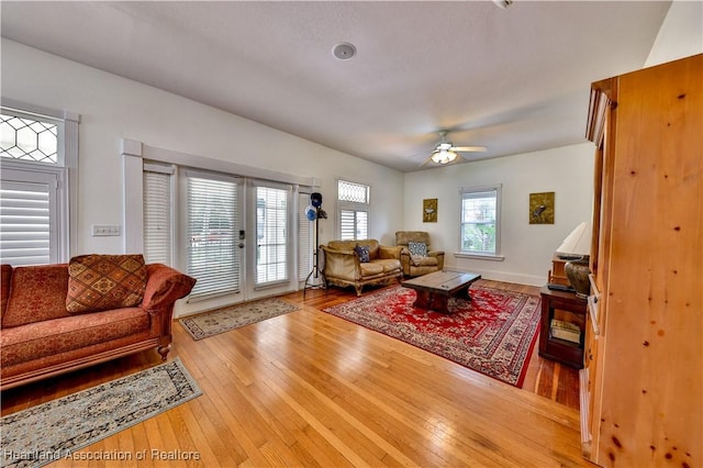 living room with ceiling fan, hardwood / wood-style floors, and french doors