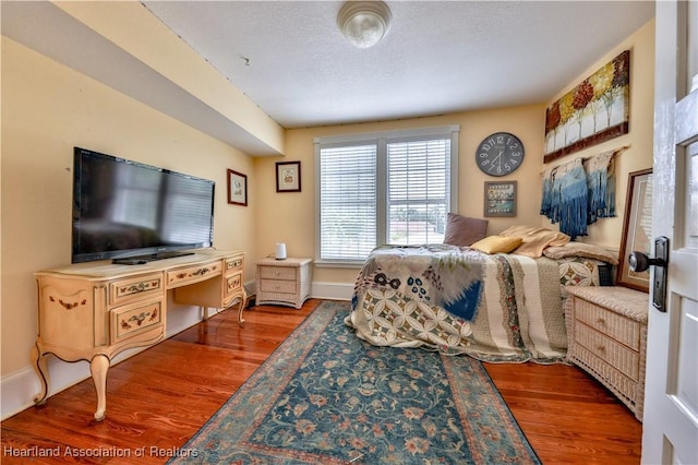 bedroom featuring hardwood / wood-style floors and a textured ceiling