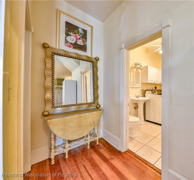 corridor featuring sink, light hardwood / wood-style flooring, and washer / dryer