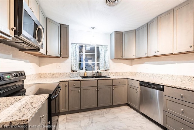 kitchen featuring marble finish floor, appliances with stainless steel finishes, gray cabinets, and a sink