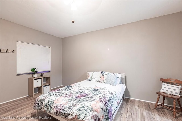 bedroom featuring wood finished floors and baseboards