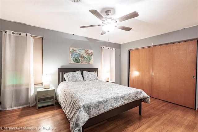 bedroom with a closet, wood finished floors, and a ceiling fan