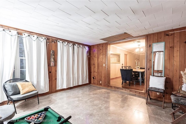 sitting room featuring wood walls and a notable chandelier