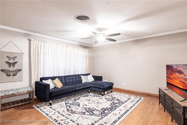 living area with ornamental molding, light wood-style flooring, and visible vents