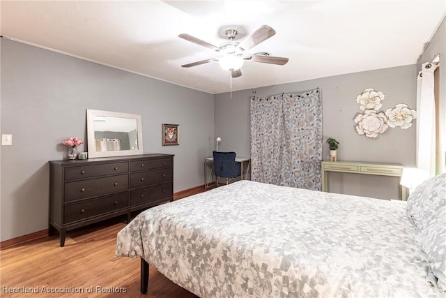 bedroom with ceiling fan, wood finished floors, and baseboards