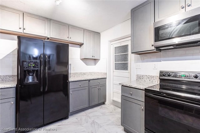 kitchen with black appliances, tasteful backsplash, marble finish floor, and gray cabinets