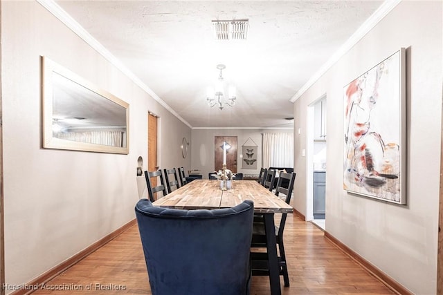 dining area featuring baseboards, ornamental molding, visible vents, and light wood-style floors