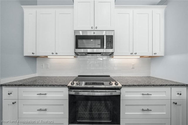 35151 Daily Dr, Sebring, FL 33872 - kitchen featuring dark stone countertops, white cabinetry, stainless steel appliances, and tasteful backsplash