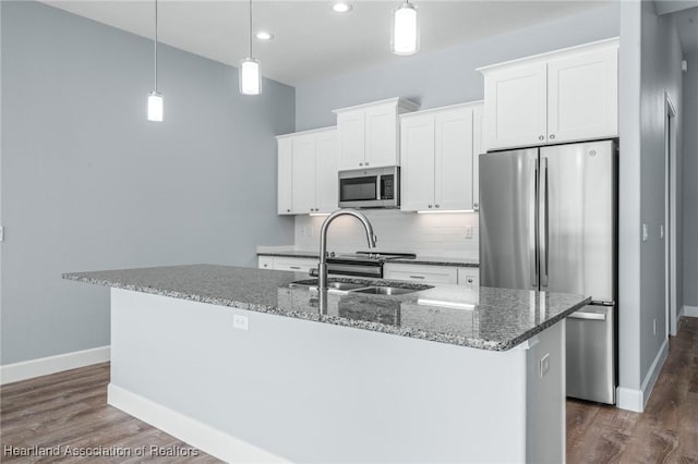 kitchen featuring a kitchen island with sink, white cabinets, and appliances with stainless steel finishes