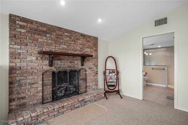 unfurnished living room featuring vaulted ceiling, light tile patterned flooring, and a fireplace