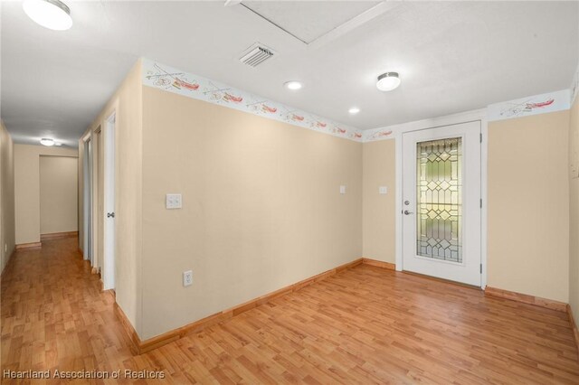 empty room with light wood-style flooring, baseboards, and recessed lighting