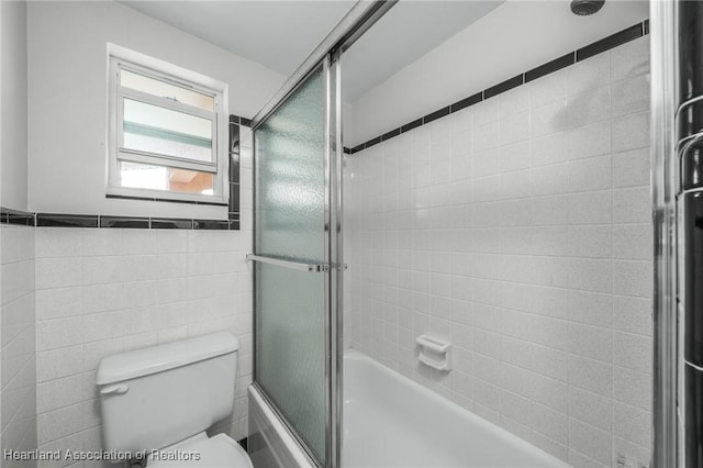 bathroom with enclosed tub / shower combo and toilet