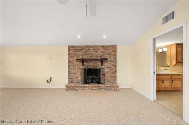 unfurnished living room with carpet, ceiling fan, a brick fireplace, vaulted ceiling, and recessed lighting