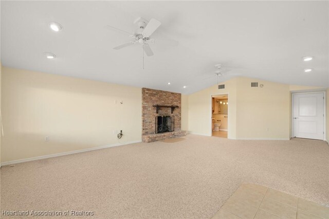 unfurnished living room with ceiling fan, light carpet, lofted ceiling, a brick fireplace, and recessed lighting