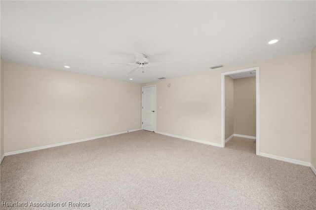 empty room featuring light carpet, recessed lighting, a ceiling fan, and baseboards