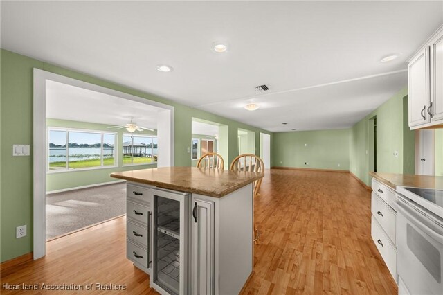 living area with light wood-style flooring and ceiling fan