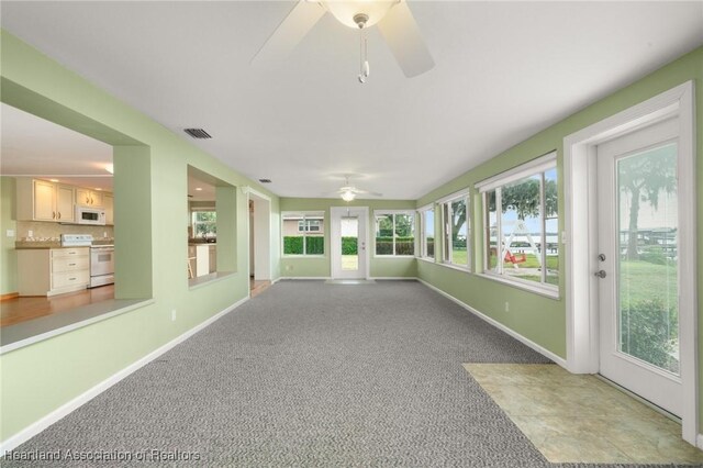 unfurnished sunroom with baseboards and carpet floors
