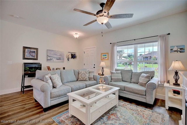 living room featuring ceiling fan and dark hardwood / wood-style flooring