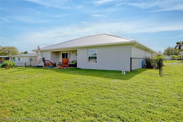 rear view of property featuring a lawn