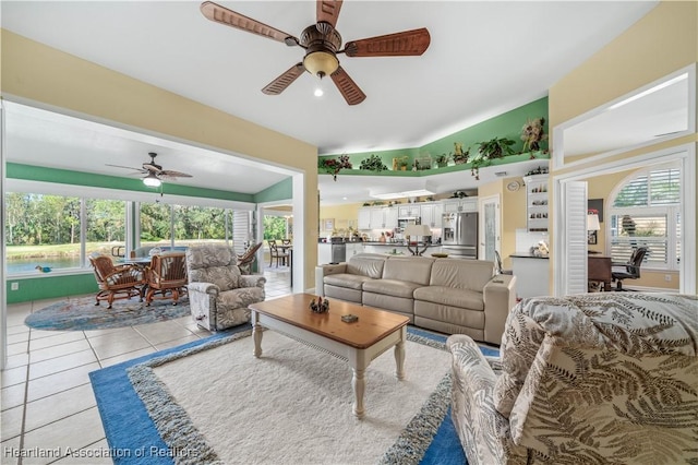 tiled living room featuring ceiling fan and vaulted ceiling