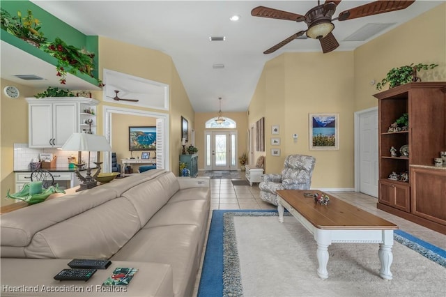 tiled living room featuring french doors and vaulted ceiling