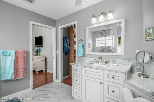 bathroom featuring vanity, ceiling fan, and a shower