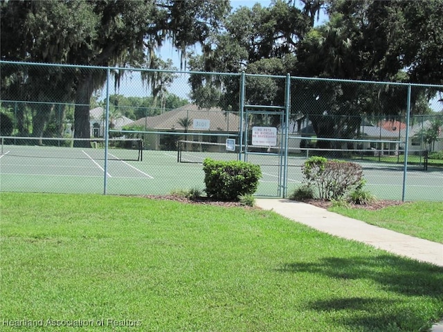 view of sport court with a yard