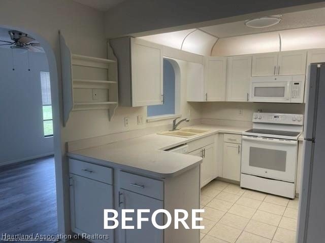 kitchen with open shelves, white appliances, a sink, and white cabinets