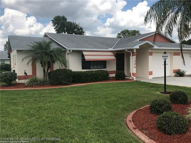 single story home with a garage and a front lawn