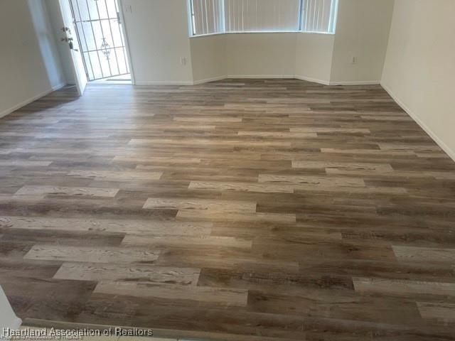 empty room with dark hardwood / wood-style flooring