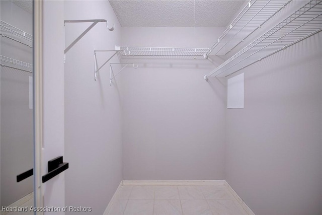 walk in closet with marble finish floor