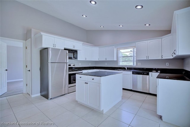 kitchen featuring appliances with stainless steel finishes, dark countertops, recessed lighting, and lofted ceiling