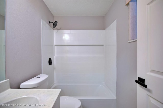 bathroom featuring a textured ceiling, vanity, toilet, and bathtub / shower combination