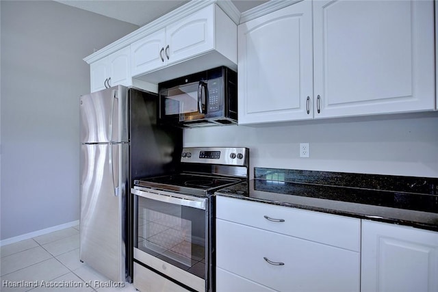 kitchen with baseboards, dark stone counters, light tile patterned floors, stainless steel appliances, and white cabinetry