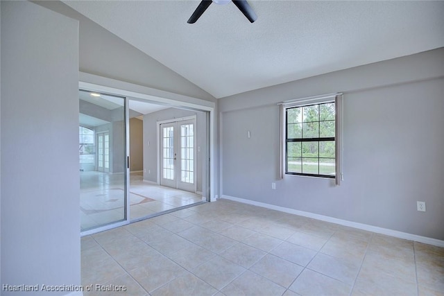 interior space featuring light tile patterned floors, ceiling fan, vaulted ceiling, and multiple windows