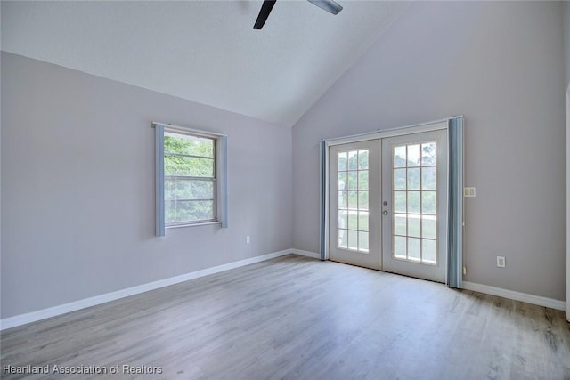 unfurnished room with high vaulted ceiling, ceiling fan, baseboards, french doors, and wood finished floors