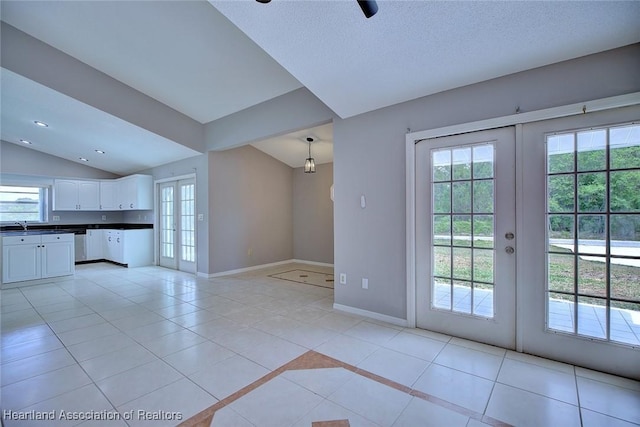 unfurnished living room featuring light tile patterned flooring, a wealth of natural light, and french doors