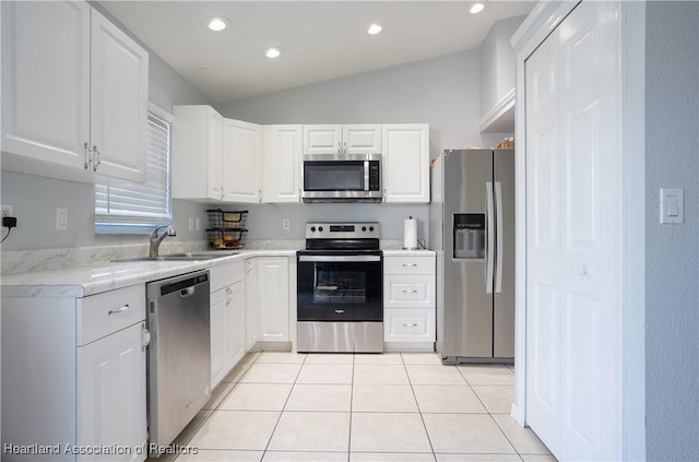 kitchen featuring lofted ceiling, sink, white cabinetry, and appliances with stainless steel finishes