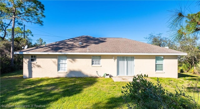 rear view of property featuring a lawn