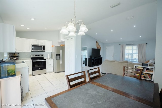 kitchen featuring sink, decorative light fixtures, light tile patterned floors, appliances with stainless steel finishes, and white cabinets