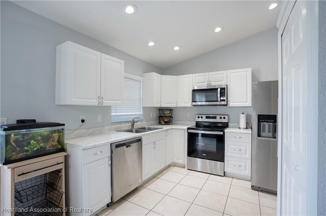 kitchen with white cabinetry, sink, stainless steel appliances, and lofted ceiling