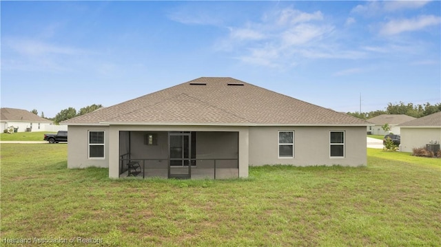 rear view of property featuring a sunroom and a yard